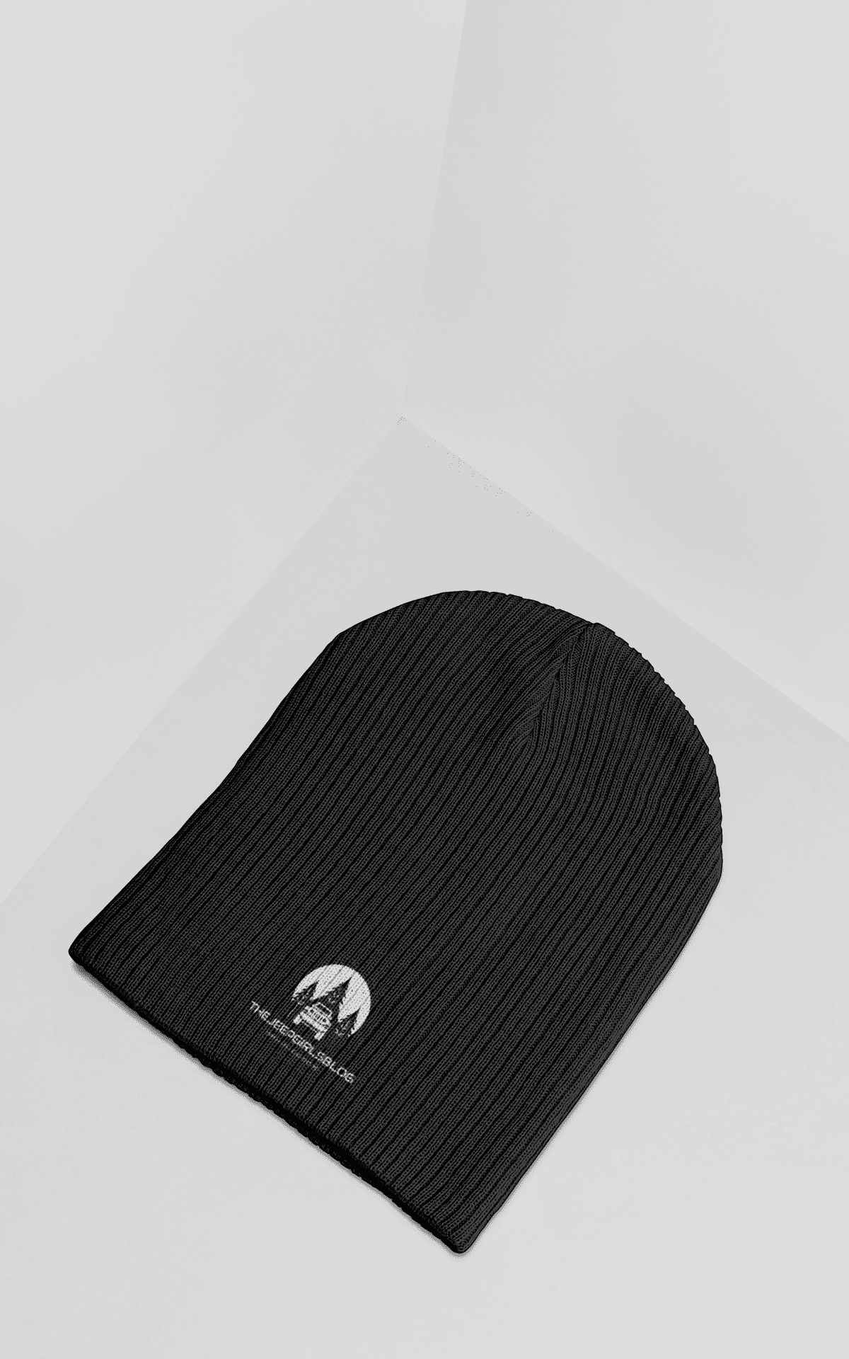 mockup of a knit beanie lying on a colored surface 25182 2 edited