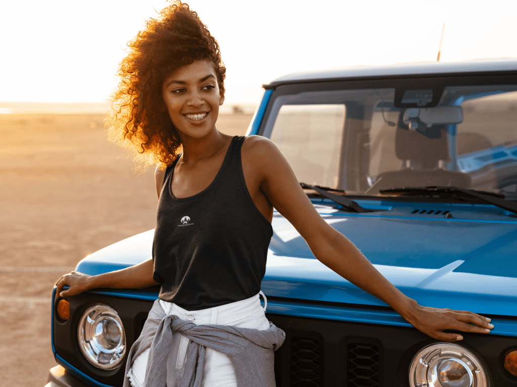 tank top mockup of an adventurous woman posing by a truck m1340 r el2